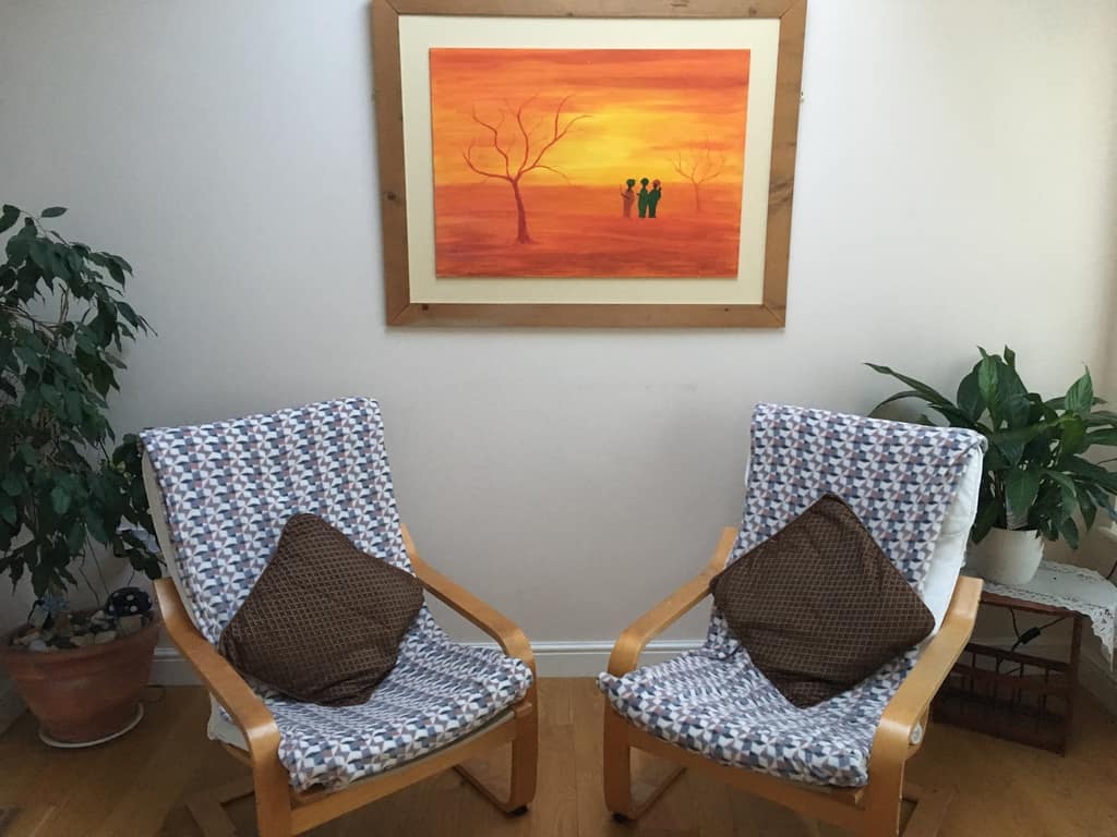 The therapy room Two armchairs in Sonya Hudson's therapy room beneath a sunset painting
