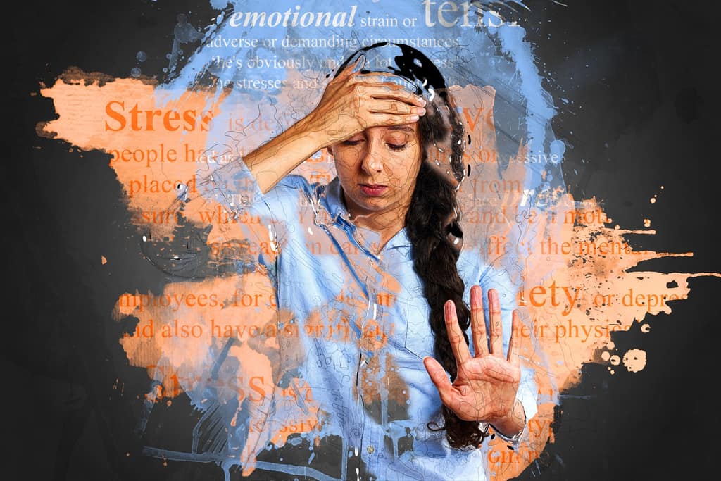 Emotional stress Stressed woman holding her head among paint-splashed words
